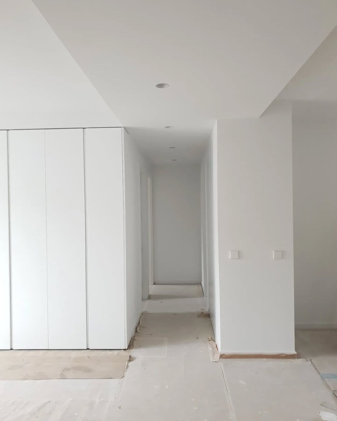 Pasillo de vivienda en reforma con paredes blancas