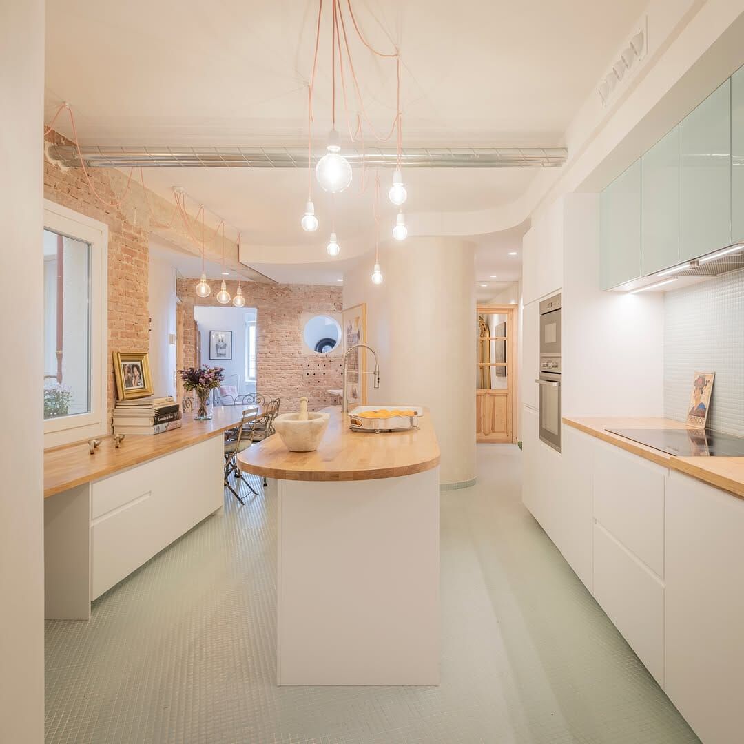 Reforma integral finalizada de cocina moderna con detalles de ladrillo y diseño minimalista